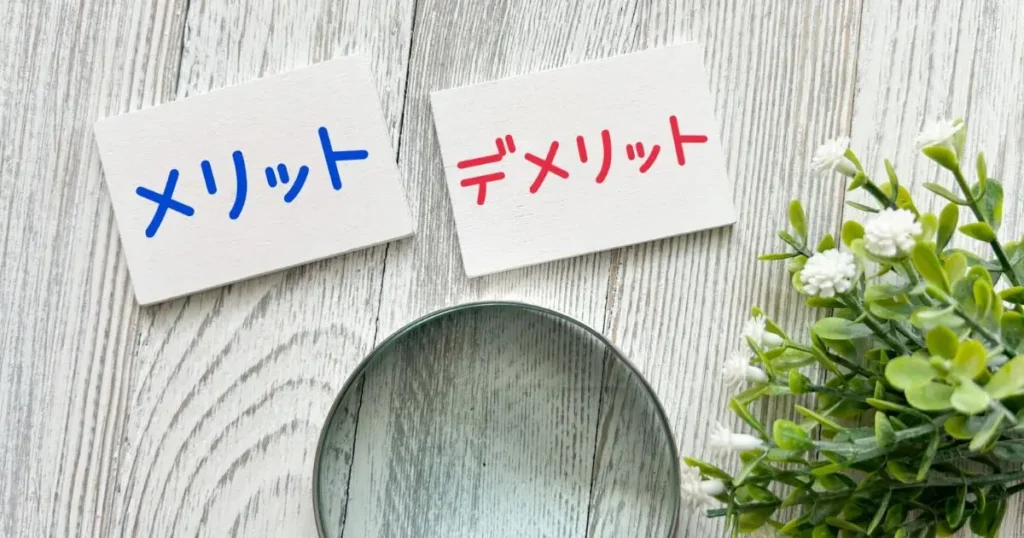 メリットと書かれた紙とデメリットと書かれた紙が並んでいる画像